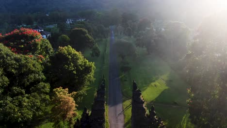 Bright-sunshine-over-luxury-resort-and-gates-of-Handara,-aerial-fly-backward-view