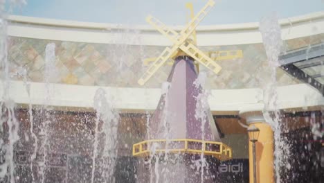 Slow-Motion-Of-Fountains-With-Windmill-On-Background