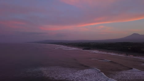 Pink-sky,-purple-ocean-sunrise-over-Kuta-Mandalika-beach-on-Lombok
