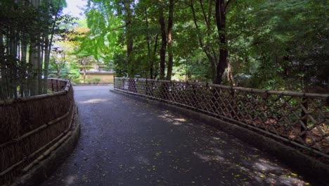 Un-Hermoso-Camino-En-Un-Templo-Budista-En-Japón,-Con-Un-Gran-Bosque-De-Bambú-Al-Costado-Del-Camino