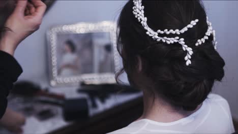 Bridesmiaid-decorating-the-bride-hair-with-a-white-diadem