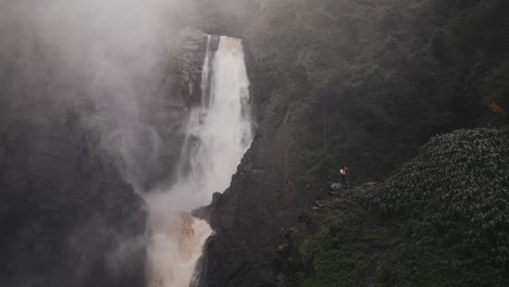 People-At-The-Edge-Of-A-Cliff-With-Salto-de-Bordones-In-Isnos,-Huila,-Colombia