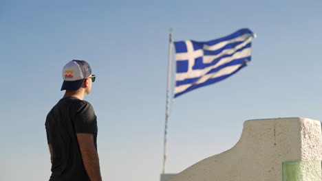 Ein-Mann-Steht-Neben-Einer-Wehenden-Griechischen-Flagge