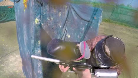 POV-shot-of-paintballer-playing-in-outdoor-arena-getting-hit-by-paintballs,-also-hitting-camera