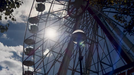 Static-shot-of-a-Ferris-wheel-slowly-turning-on-a-bright-summers-day
