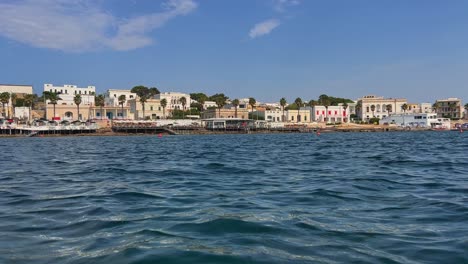 Coast-of-Santa-Maria-di-Leuca-south-Italian-town-seen-from-sailing-boat-moving-along-Ionian-coast-of-Salento-in-Apulia,-Italy