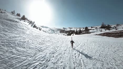Fpv-Schuss,-Der-Um-Den-Skifahrer-Kreist,-Der-Den-Schneebedeckten-Hügel-Hinaufgeht