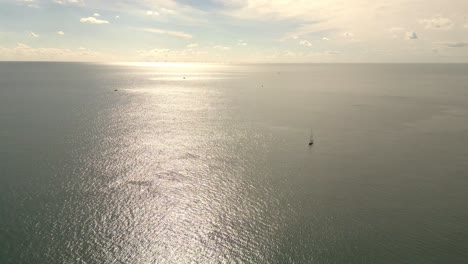 Luftaufnahme-Schöne-Aussicht-Sonnenuntergang-über-Der-Meeresoberfläche-Schöne-Welle-Mit-Segelbooten-Im-Hintergrund-Erstaunliche-Licht-Sonnenuntergang-Oder-Sonnenaufgang-Himmel-über-Dem-Meer-Strand-Mit-Welle-Im-Ozean