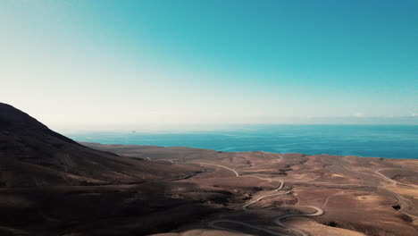 Dirt-road-through-barren-landscape-leads-to-Playa-de-Cofete,-Fuerteventura