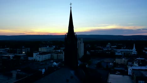 Droning-towards-a-church-steeple-during-a-sunset-in-Wilkes-Barre,-Pennsylvania