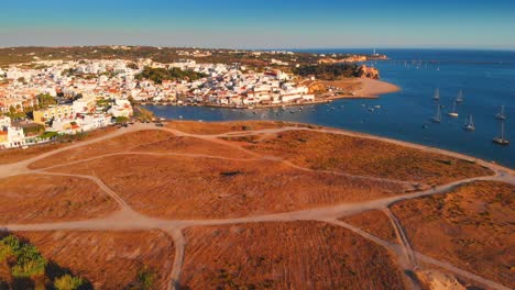 Zoom-out-drone-shot-of-the-beautiful-coast-and-beach-of-Ferragudo-Portugal-4K