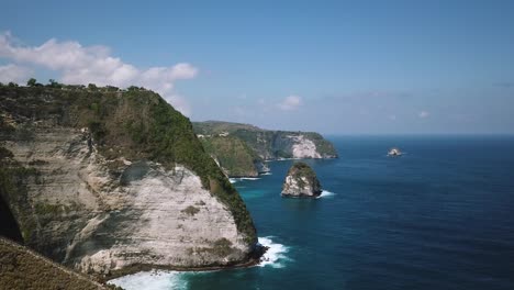 Rising-Drone-Shot-revealing-the-beautiful-KelingKing-cliffs-of-the-island-of-Nusa-Penida,-Indonesia