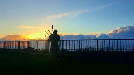 Bagpiper-facing-a-magnificent-sunset-on-top-of-a-coastal-bluff-overlooking-Half-Moon-Bay