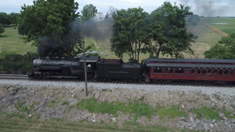 Aerial-View-of-a-Vintage-Steam-Engine-with-Passenger-Cars-Puffing-along-Amish-Countryside