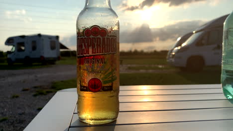 4K-Close-up-from-a-delicious-cold-desperados-tequila-beer-to-the-campsite-in-Netherlands-during-sunset