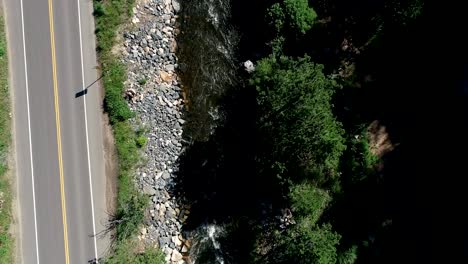 A-drone-shot-of-a-full-spin-above-a-running-river-in-60fps-at-4k