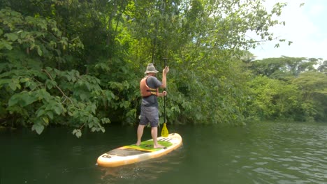 A-bearded-ginger-man-paddling-on-a-stand-up-paddle-board-on-the-river-Nile