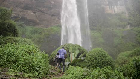 A-group-of-African-men-hiking-at-the-base-of-Sipi-falls-Uganda