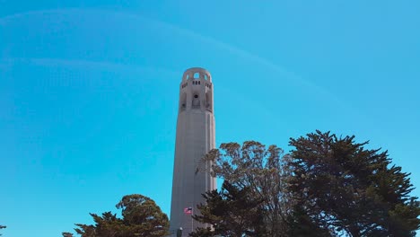 Aufnahme-Des-Coit-Towers,-Der-Im-Sommer-In-San-Francisco,-Kalifornien,-Usa,-Vom-Geparkten-Auto-Zum-Turm-Mit-Blauem-Himmel-Im-Hintergrund-Hochschwenkt