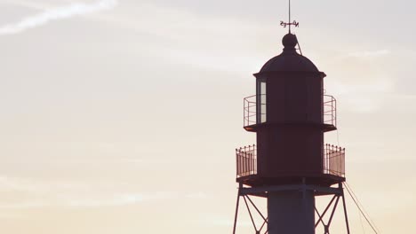 Schöne-Aussicht-Auf-Den-Pape-Leuchtturm-An-Einem-Ruhigen-Sommerabend-Mit-Langsam-Ziehenden-Wolken-Vor-Dem-Sonnenuntergang,-Mittlere-Aufnahme