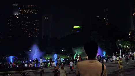 People-marvel-at-the-dancing-fountain-lights-in-a-public-space-during-the-night-in-Singapore