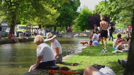 Slow-motion-shot-of-bourton-on-the-water-in-the-busy,-hot-summer-showcasing-the-tourist-hotspot-of-the-cotswolds
