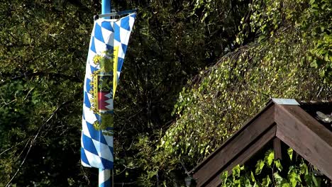 Close-up-of-Bavarian-flag-waving-in-the-wind-in-front-of-a-summerhouse,-Germany