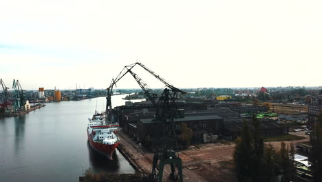 Drone-flying-around-cranes-and-cargo-ships-in-the-shipyard-docks-1