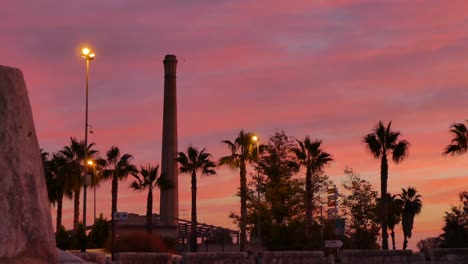 Lovely-time-lapse-of-a-sunrise-with-passing-cars-and-in-the-background-the-tower-of-an-old-factory