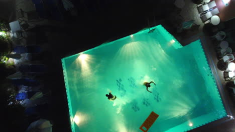 Jumping-in-pool-at-night-from-above