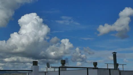 Das-Dach-Eines-Gebäudes-Und-Vorbeiziehende-Weiße-Wolken