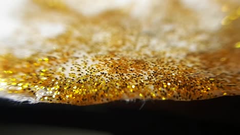 Golden-Wet-Glitter-On-a-Uneven-Edge-Of-Paper