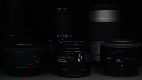 The-light-moves-slowly-over-the-camera-lenses-without-visible-brands-on-a-black-dark-background