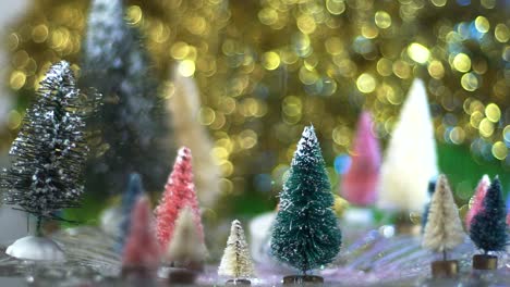 Slow-Motion-snow-glitter-falls-on-Whimsical-bottle-brush-tree-forest-with-gold-bokeh-background