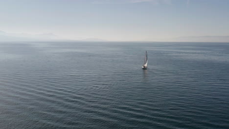 Flying-up-to-single-sail-boat-on-a-vast-empty-sea