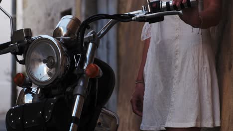 beautiful-woman-wearing-white-dress-holding-cool-motorcycle-handle-bars-in-slow-motion-filmed-prores-raw