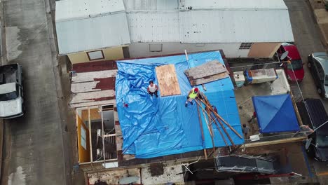 Luftaufnahme-Von-Menschen-Bei-Wiederaufbauarbeiten-Des-Hausdachs-Nach-Hurrikan-Maria-Schäden,-Puerto-Rico