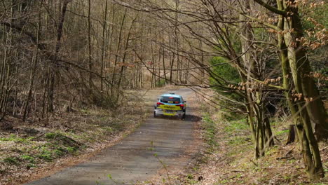 Driving-through-a-light-curve-looking-at-the-back-of-a-rally-car-from-which-stones-and-leaves-fly-during-a-racing-autumn-day-at-a-Valasska-Rally-captured-in-120fps-slow-motion