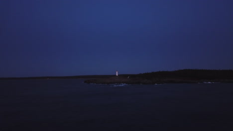 Twilight-Over-Remote-Island-Coast-and-Isolated-Lighthouse-Tower,-Dramatic-Cinematic-Aerial-Sea-View