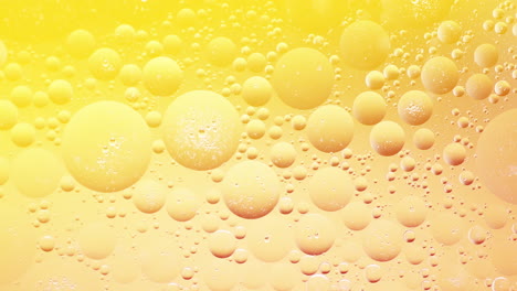 Peaceful-shot-of-bubbles-illuminated-with-yellow-light-move-around,-slow-motion