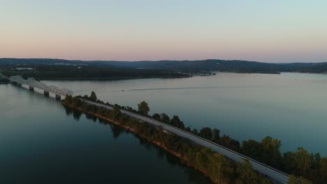 Aerial-view-of-the-vastness-of-a-large-lake-then-panning-towards-a-bridge-and-highway-across-the-lake