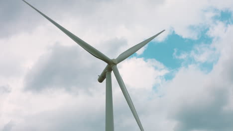 Slow-motion-wind-turbine-blades-rotating-against-a-cloudy-background