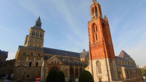 Dolly-shot-revealing-Maastricht's-famous-twin-churches,-the-Sint-Servaasbasiliek-and-the-Sint-Janskerk,-in-daylight-with-blue-sky