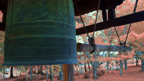Big-Japanese-bell-surrounded-by-trees-in-the-autumn-season-in-Kyoto,-Japan-soft-lighting-slow-motion-4K