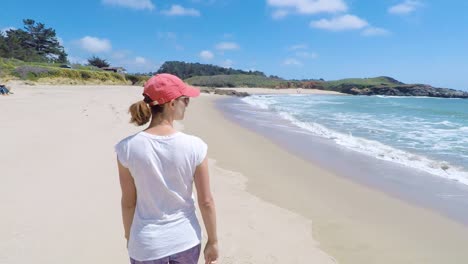 Mujer-Joven-Caminando-En-Una-Playa-En-La-Costa-Oeste,-EE.UU.