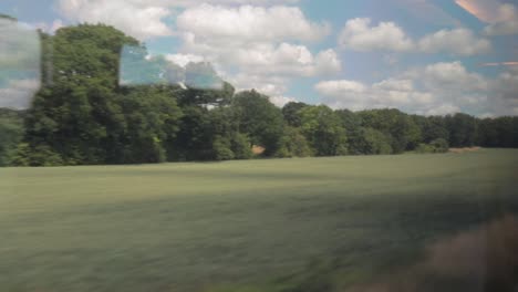View-of-countryside-on-sunny-summer-day-from-train-window
