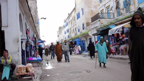 Street-view-of-local-men-and-women-shopping-in-Essaouira,-Morocco-during-the-daytime