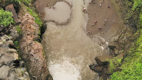 Aerial-bird's-eye-view-of-a-beautiful-tropical-waterfall-with-tourists