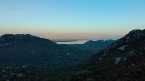 Aerial-medium-shot-of-mountain-and-lake-after-sunset