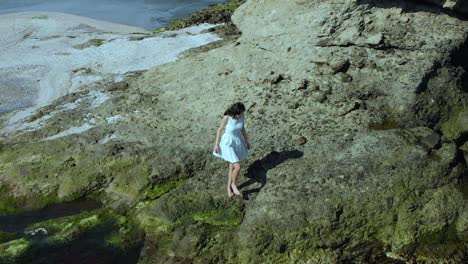 Aerial-slow-motion-shot-of-pretty-girl-in-white-dress-walk-on-the-beach-1